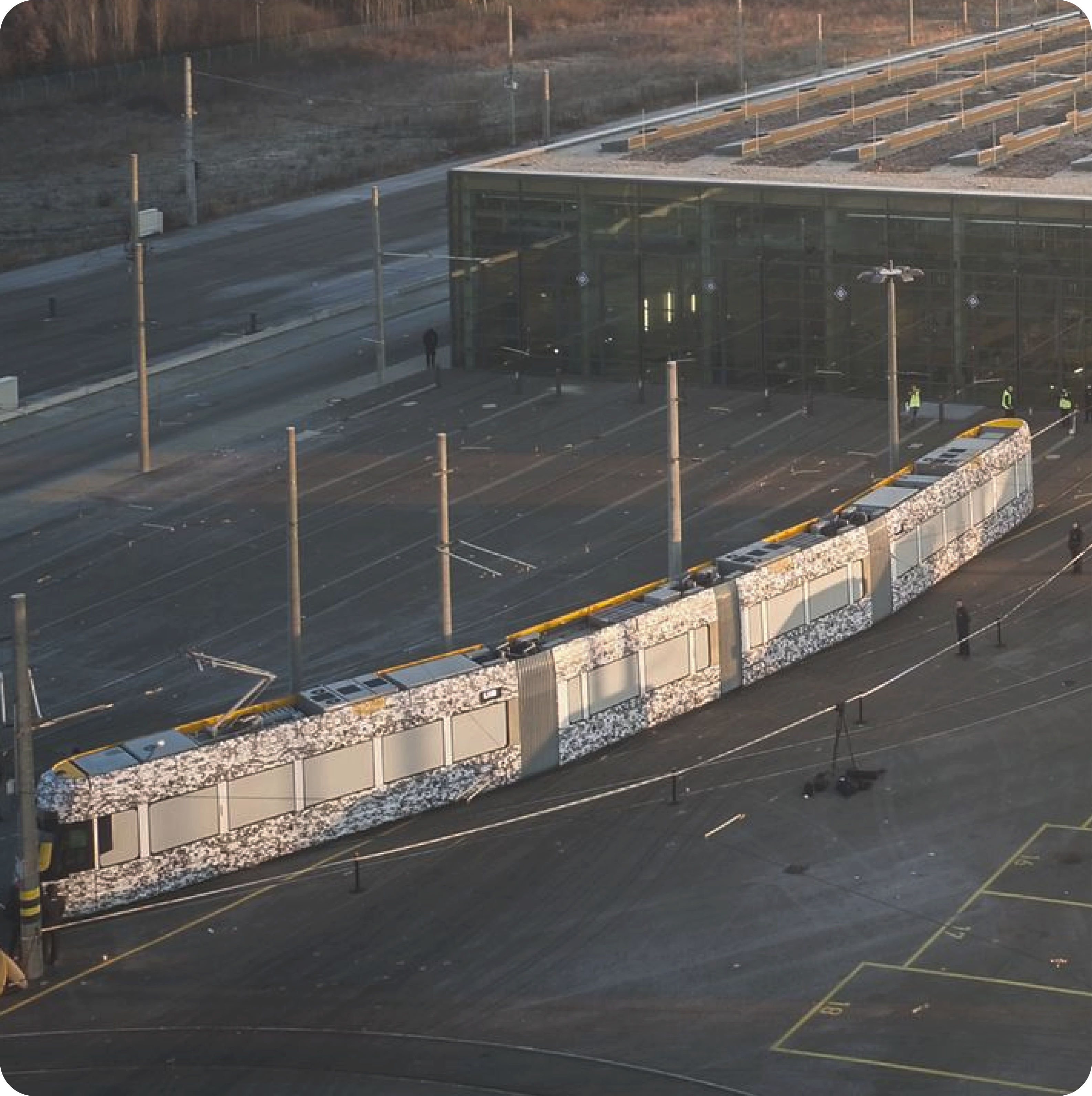 A tram stands in the morning light on the grounds of a depot