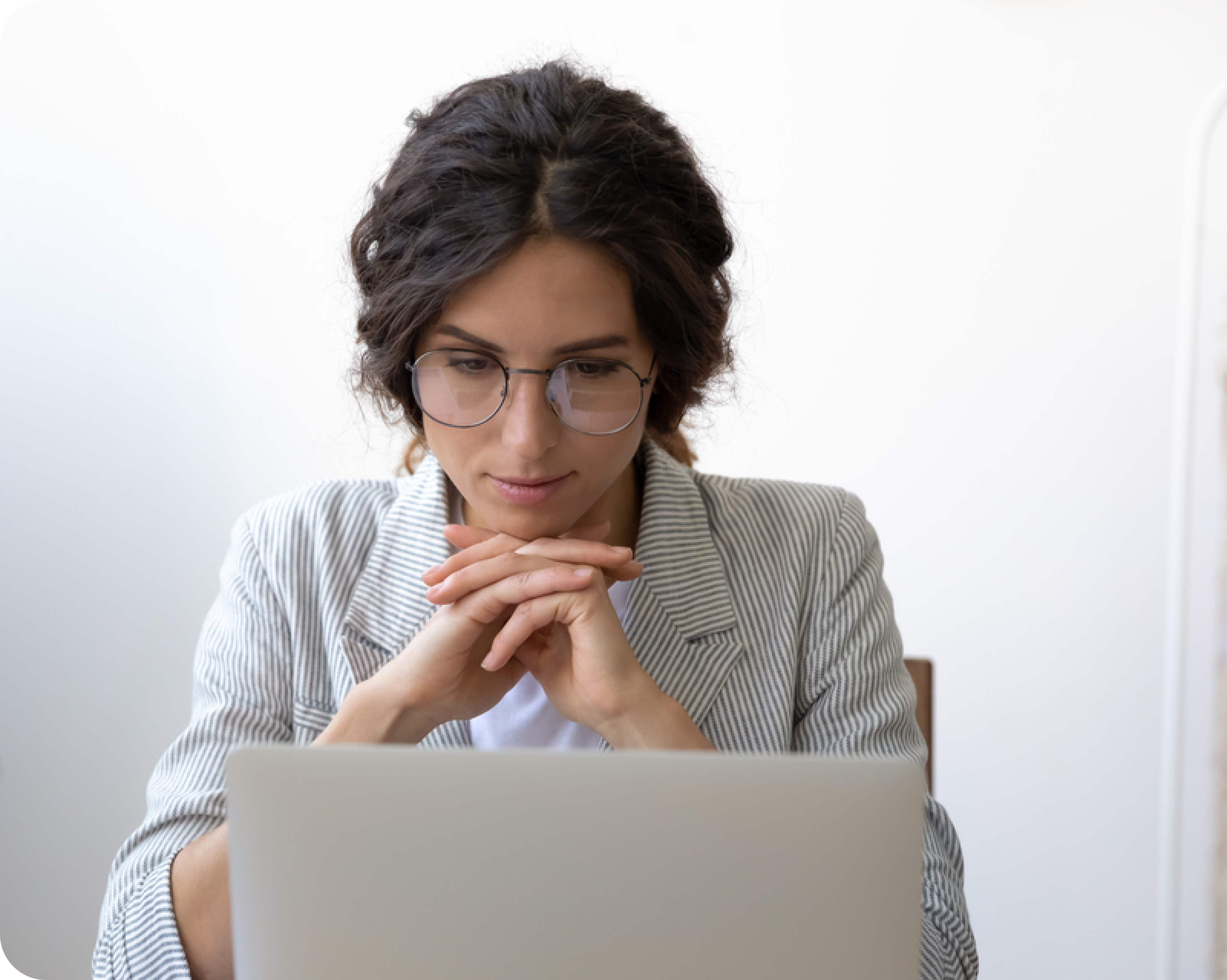 A woman sitting at her laptop, concentrating